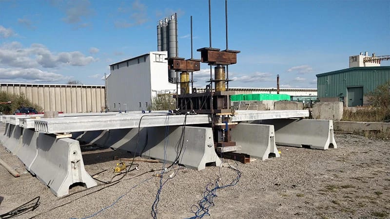 Precast Concrete Cost Guide: Pricing, ROI & Budget Planning (2026 Reliable Guide) 3 precast concrete cost factors demonstrated through structural load testing at a Canadian precast manufacturing facility